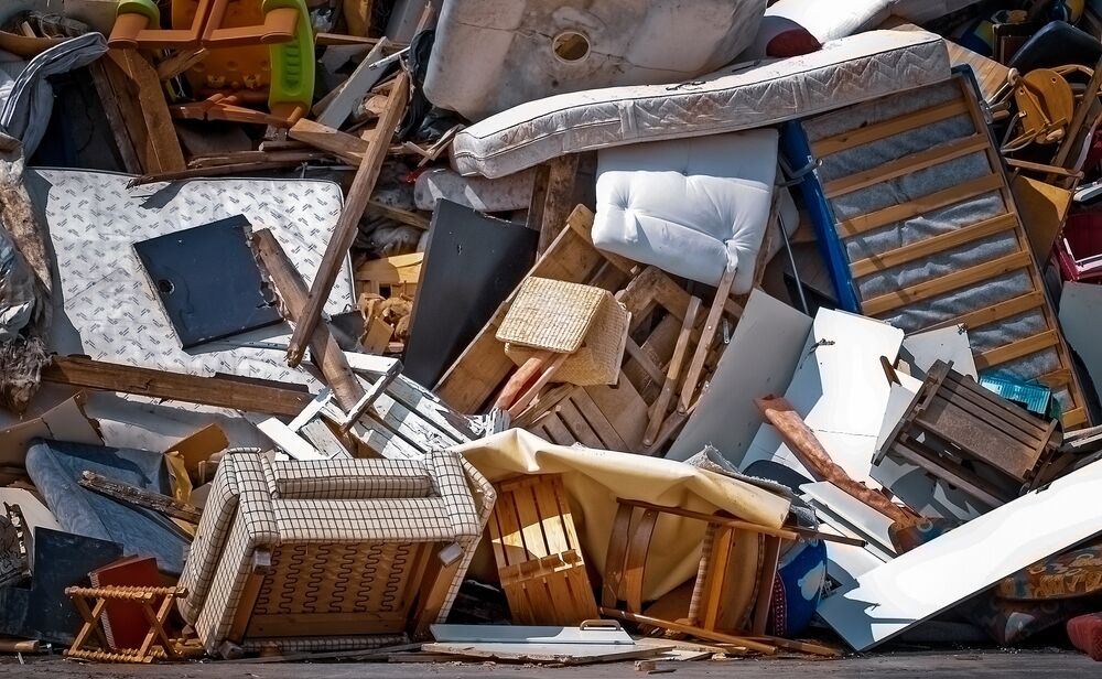 A closeup of a dump with assorted pieces of old furniture